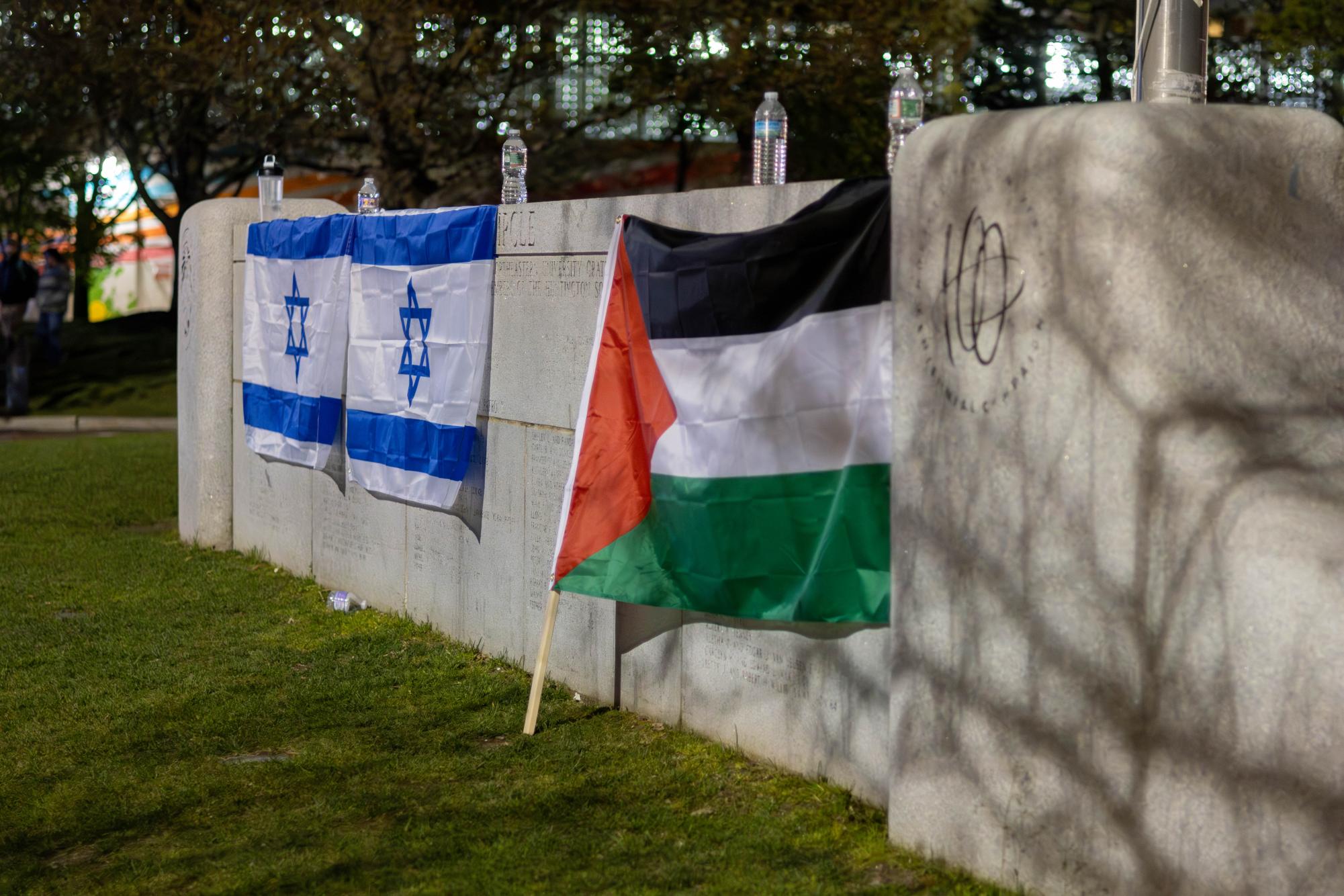 Two Israeli flags and one Palestinian flag hang from the Centennial Common ledge. Numerous protests calling for a ceasefire of the Israel-Palestine war were held on campus in the past year following Hamas' attack on Israel Oct. 7, 2023.