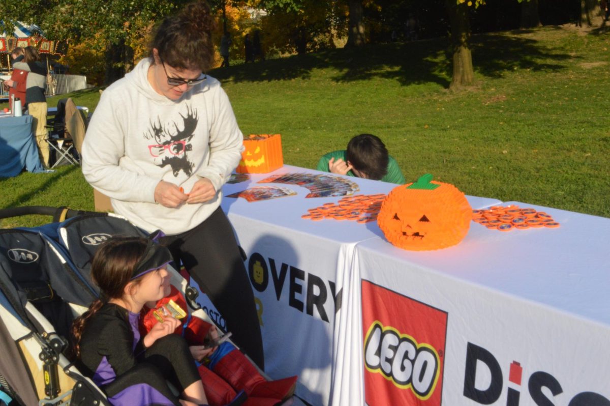 A child smiles at a Lego pumpkin. Various activities and games were spread out across Boston Common.