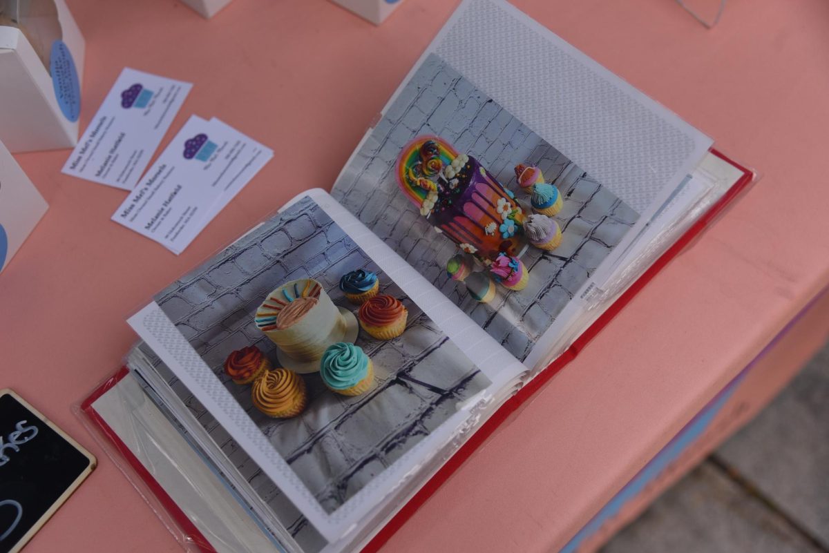 A picture book containing Miss Mel’s Morsels’ other cake creations sits on its booth’s table alongside its other offerings of baked goods for sale. Cake flavors included pumpkin with vanilla frosting and chocolate with Oreo frosting.