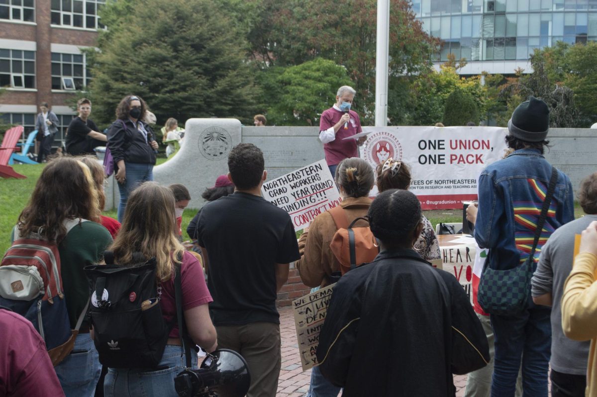 Protesters listen as Karl Klare talks into a microphone on Centennial Common. GENU-UAW held a rally Oct. 2 to voice their demands amid contract negotiations with the univerity.