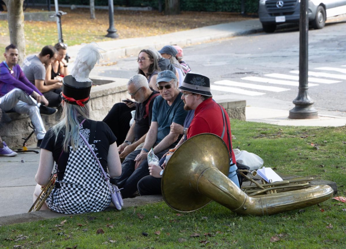 Members of several marching bands rest between sets outside the Davis Square T station. Some bands performed for hours during the festival, moving from location to location to play their sets.