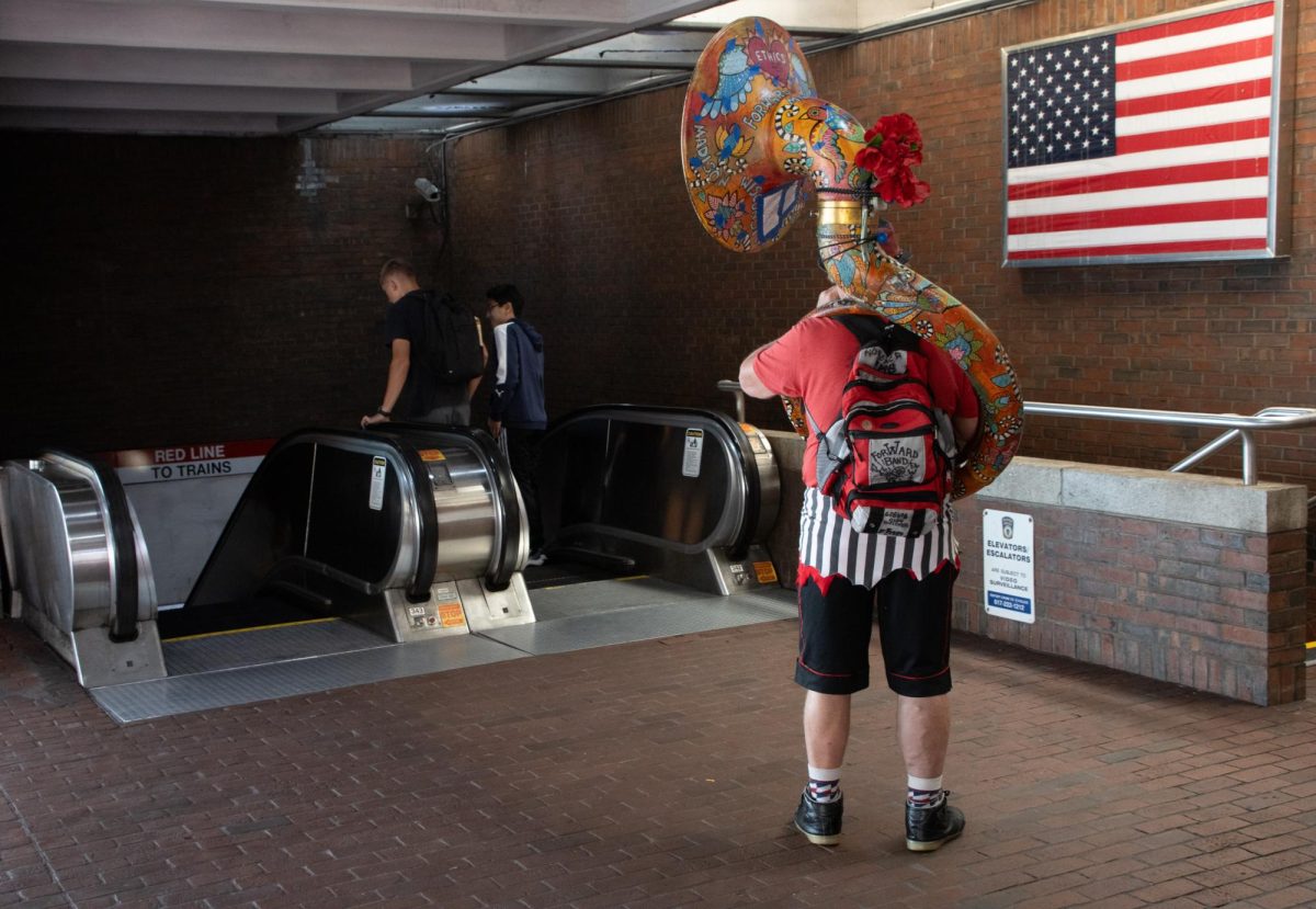 A tubist from the Forward! Marching Band performs inside the Davis Square T Station. Some musicians took the time to paint or bedazzle their instruments with slogans, beads or small murals.