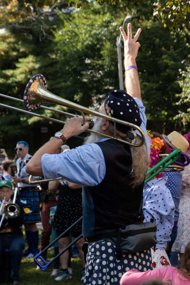 A trombone player from the School of HONK band signals a song change to the ensemble. Band leaders marked time for their bands and ensured that they moved through the setlist properly.