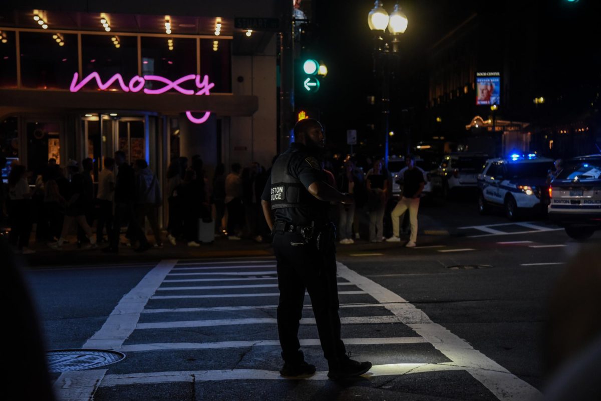 A Boston police officer uses a flashlight to direct traffic away from the picket up the street. Until about 8 p.m., the protesters made their voices heard outside the Wang Theatre before heading south to the Tufts Medical Center Orange Line station.