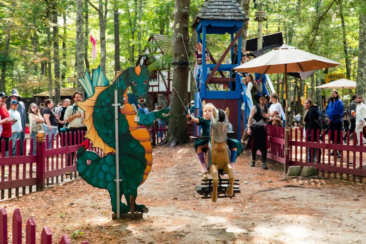 A child tries their hand at jousting at the “Dragon Joust.” To win, participants had to ride a biplane while removing a ring from the dragon with a wooden sword.