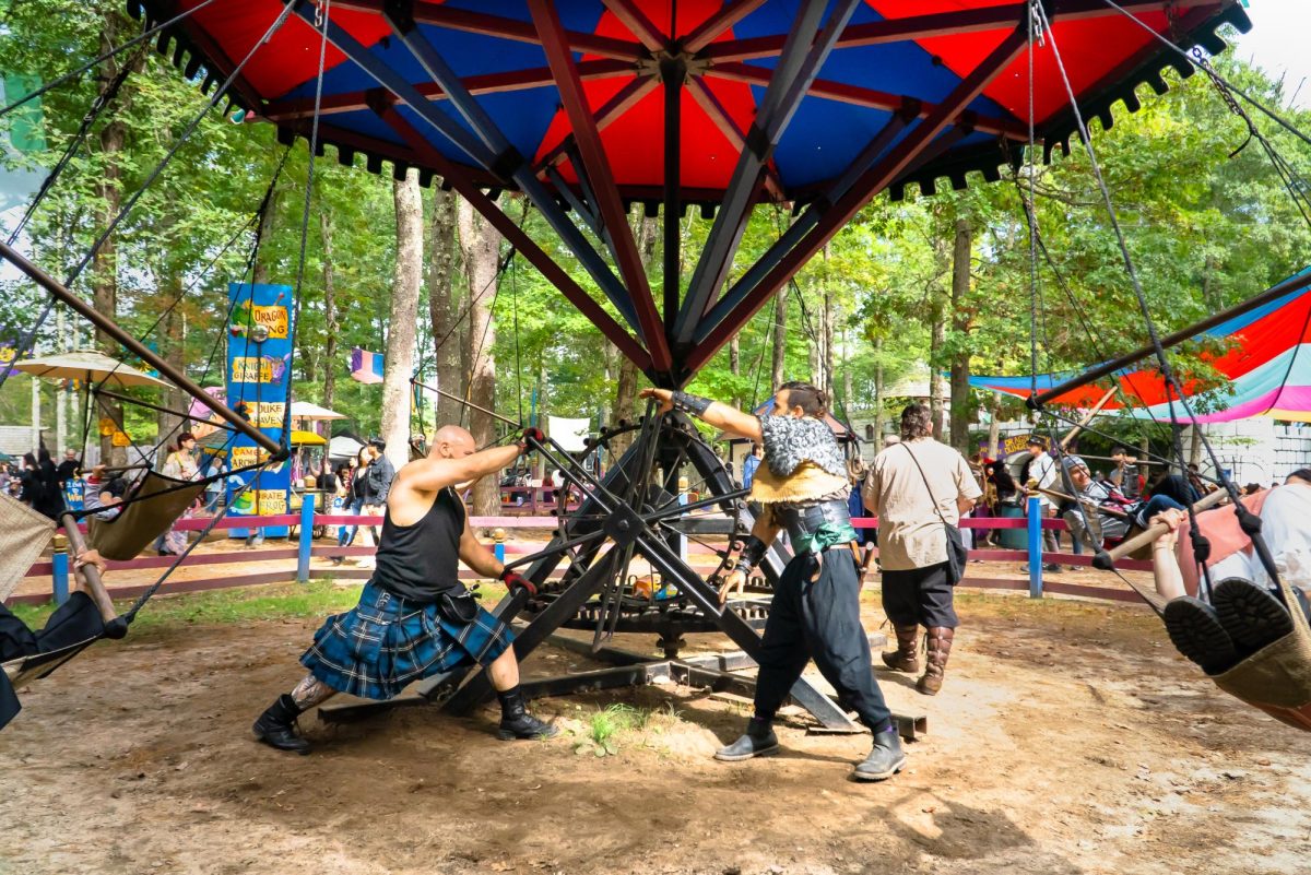 Performers manually operate a ride. The flying carousel was just one of many rides at the fair and was open to both children and adults.