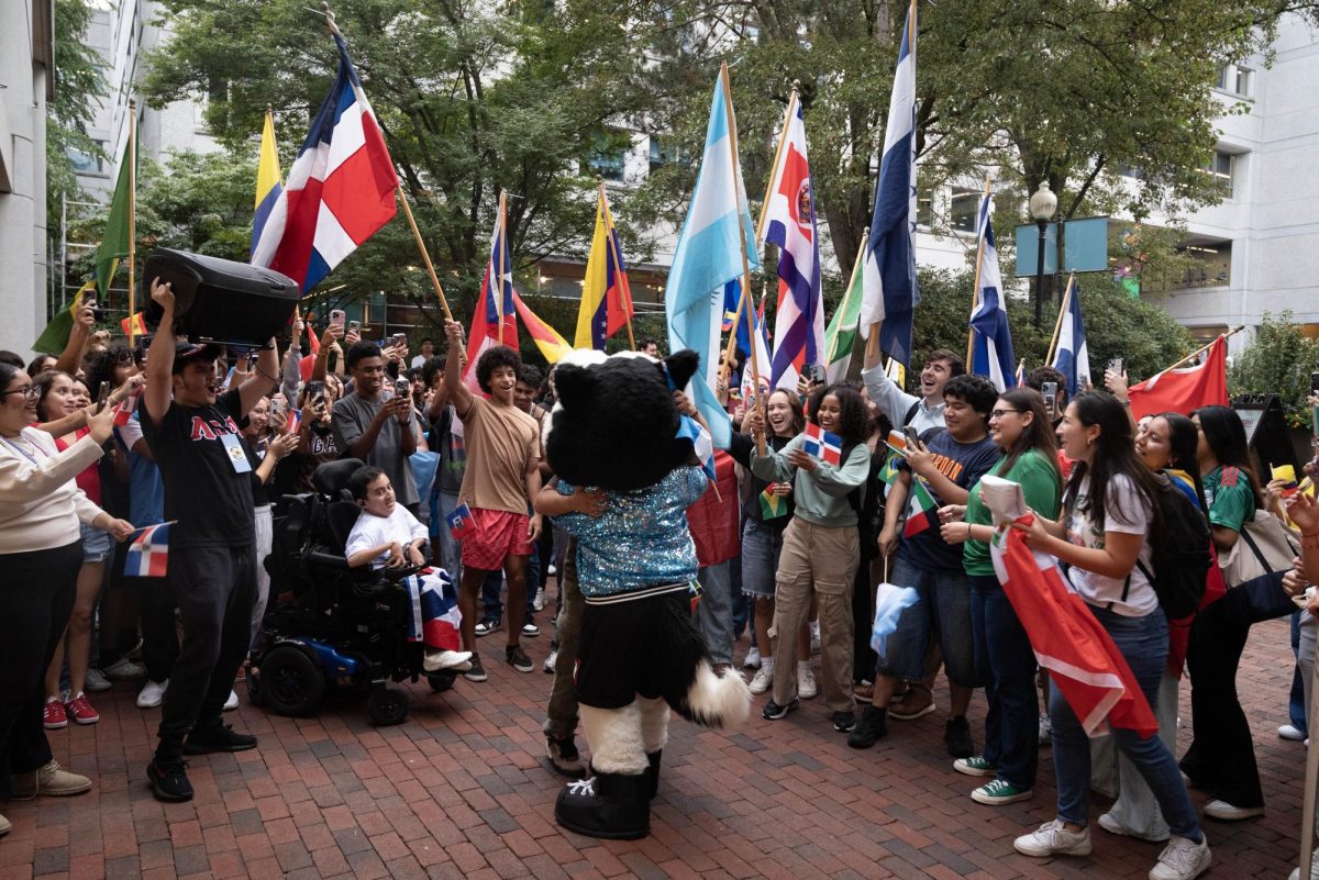 Students cheer when mascot Paws joins the parade. Paws hugged some students while they showed off their cultural pride.