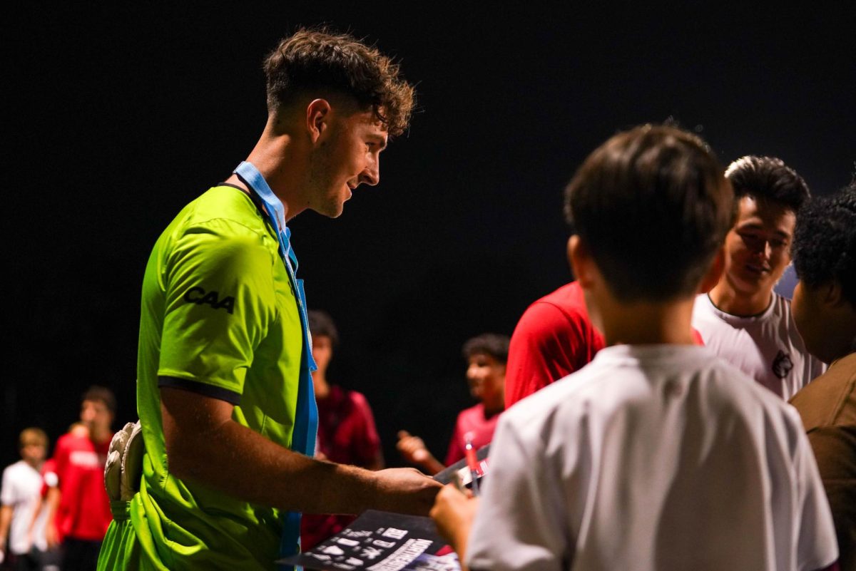 Colby Hegarty interacts with spectators at Northeastern's match against Harvard Sept. 17. The Husky helped shut out the Crimson, keeping the game to a 0-0 draw.