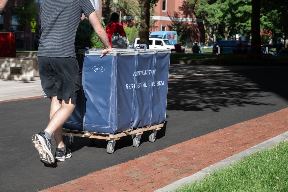 A student pushes a Northeastern moving bin. During move in week, various resources were provided to help first-years become acclimated to the university.