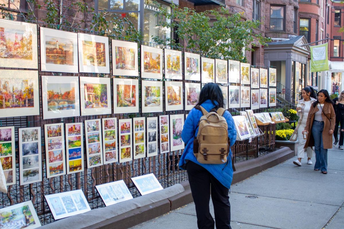 A customer looks through art prints displayed on Newbury Street.