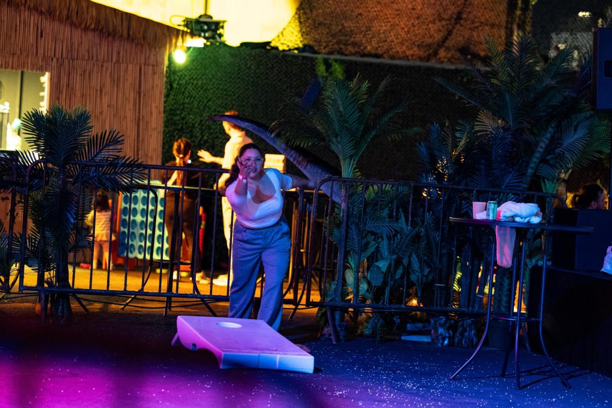 A guest throws a beanbag with her friends while enjoying the festivities and lawn games. There were many other lawn games set up, including table tennis and Connect Four.