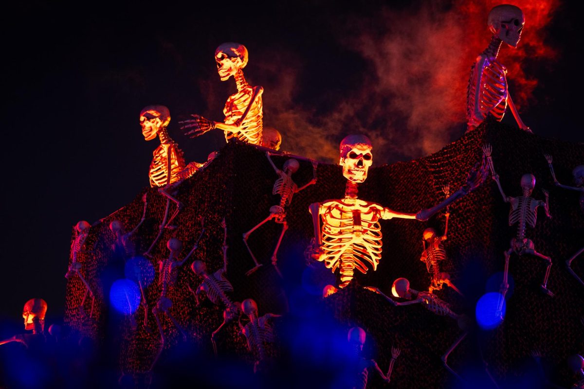 Skeletons climb a building in the middle of the festival grounds as smoke comes out around it. The skeletons climbed buildings and came to life throughout the festival.