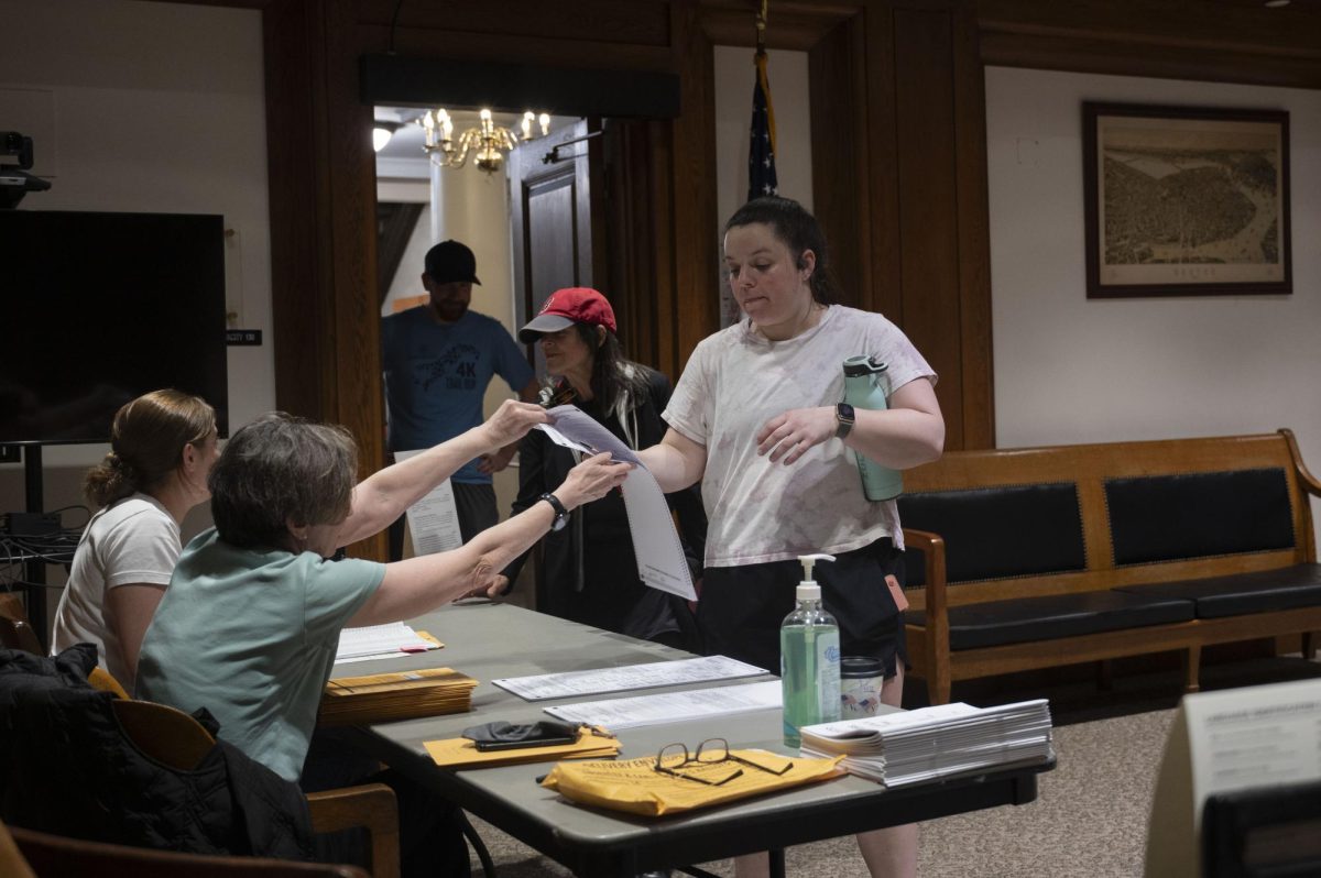 A voter receives a ballot in the State House. About 33.8% of registered voters in Massachusetts already voted prior to in-person polls opening.