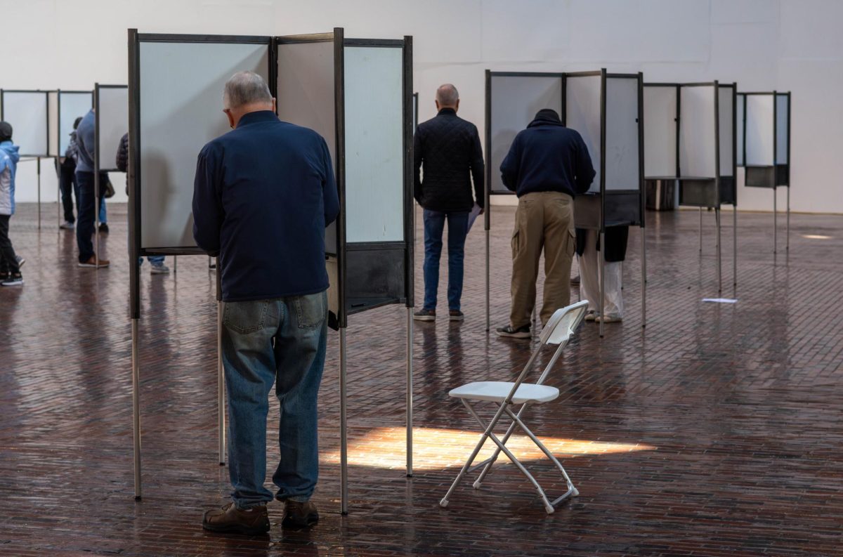 Voters at the Cyclorama fill out their ballots. Massachusetts voters turned in their ballots by filing them into voting machines with an optical scan.