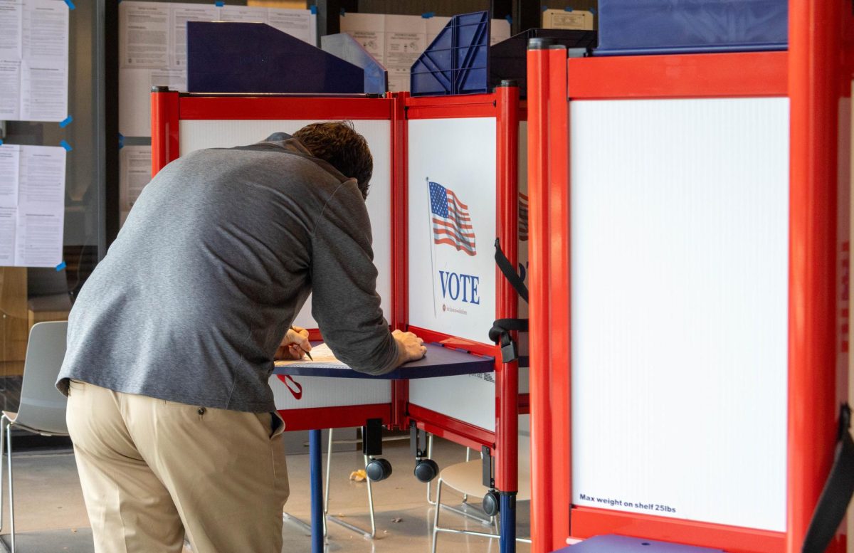 A voter fills out his ballot at the City Hall Pavilion. Many voters arrived at the polls after work around 4:30 p.m. and 5 p.m.