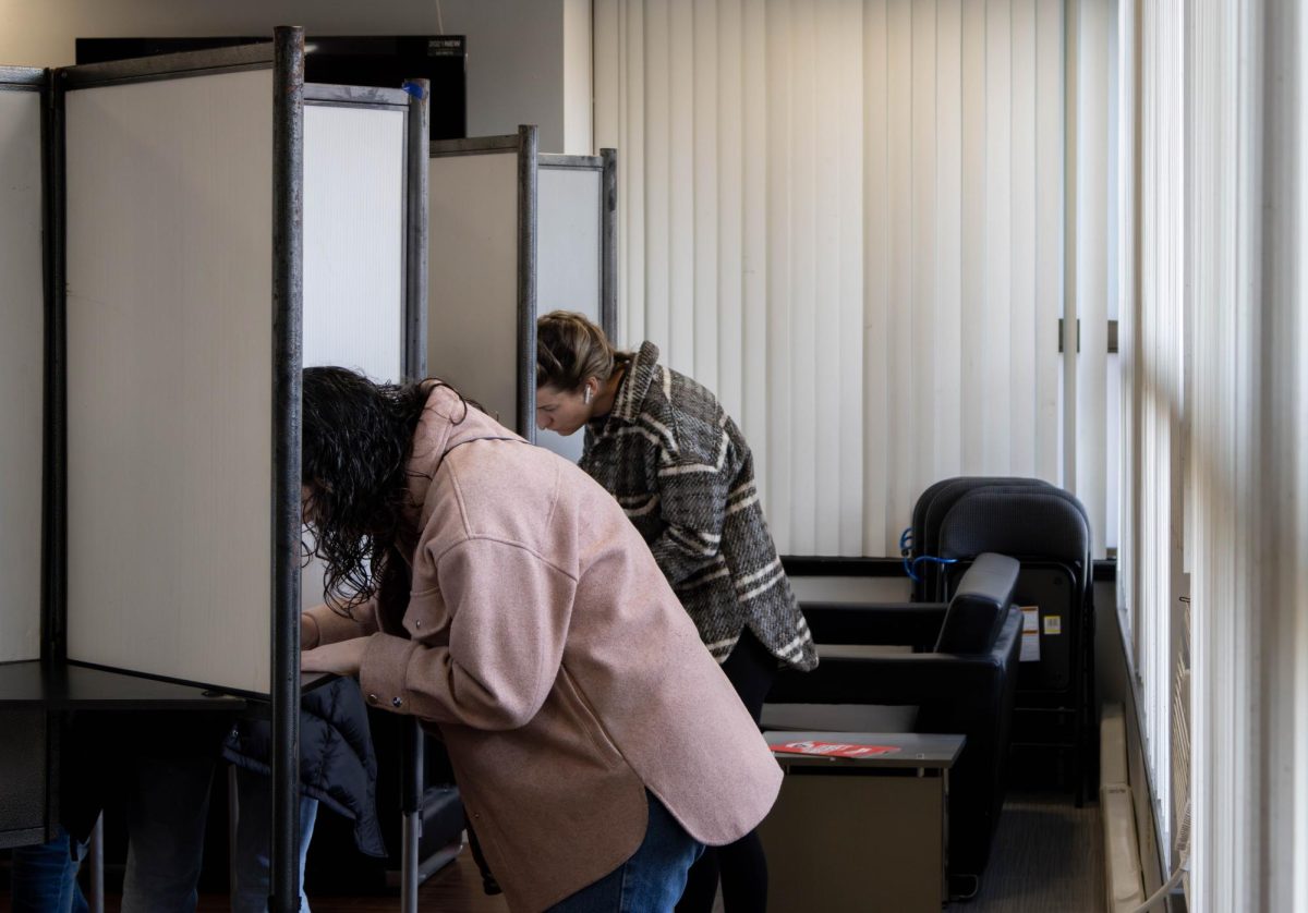 Voters at the Frederick Douglass apartments examine their ballots. All in-person voters were offered “I Voted” stickers.