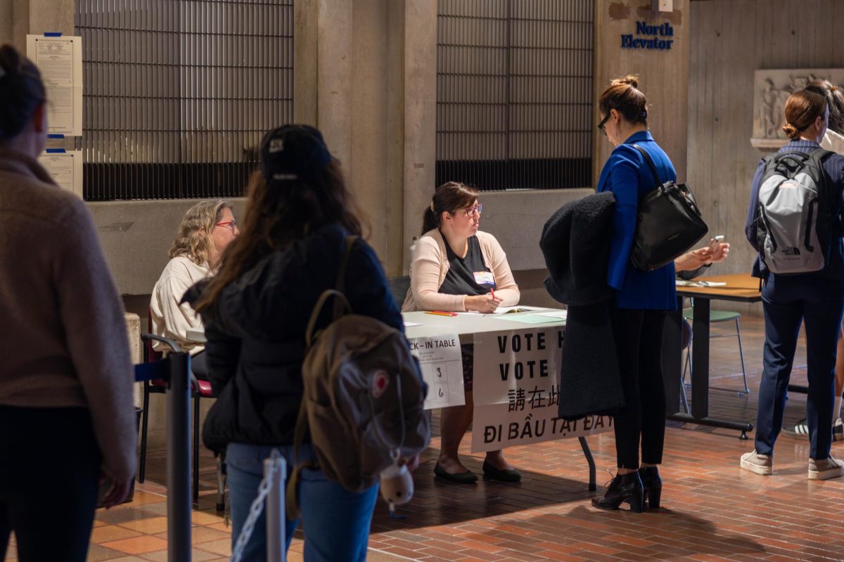 A line forms at the City Hall voting location check-in table. Voters had to give their address to the designated warden to receive their ballot.