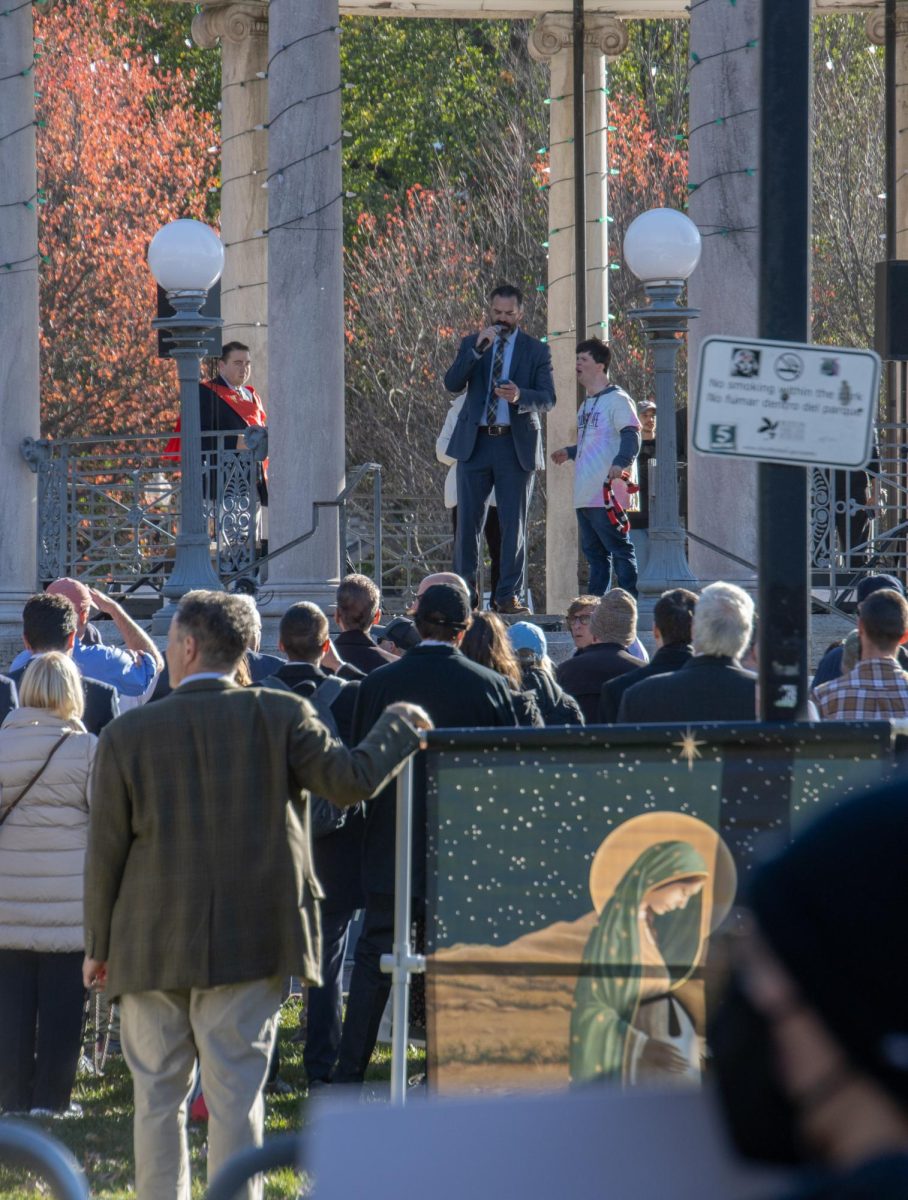 A member of the Men’s March holds a sign with an image of the Virgin Mary while Jim Havens, lead organizer of the march, gives a speech from the bandstand. The speeches were at times drowned out by music from the brass band or chanting from the counterprotesters that surrounded the barricades.