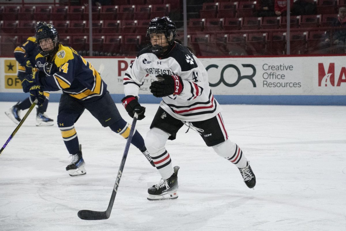 Taze Thompson skates for the puck against Merrimack Jan. 27. The captain was named Hockey East Player of the Week following a five point performance Oct. 18 and 19.