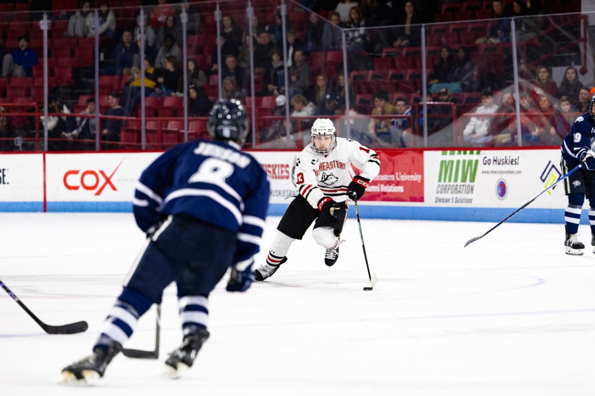 Dylan Hryckowian dribbles the puck against UNH Nov. 16. The Husky potted the winning goal over the Wildcats in a shootout.