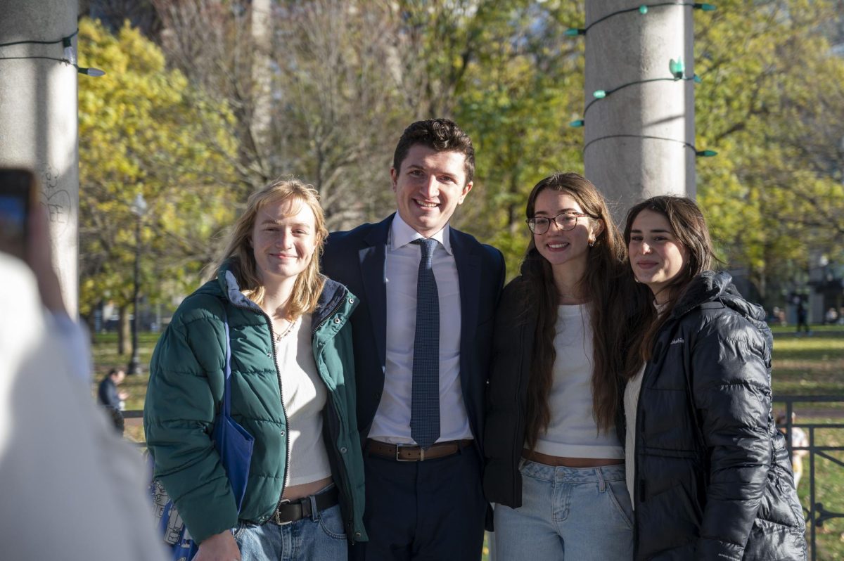 Three attendees take a photo with Anderson after the event. A long line of people waited to take a photo with him.