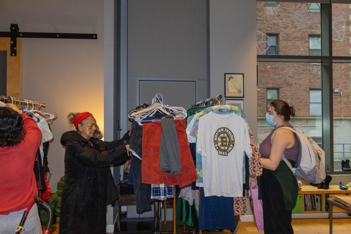 Customers at the FCC free market sift through a rack of clothes. Participants donated old clothes for others to take for free.