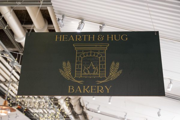 A sign for Hearth & Hug Bakery hangs above the space in the Boston Public Market. Upon opening the bakery, Natalie Hug began waking up at 4 a.m. daily to make fresh pastries for customers.