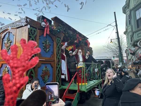 Michelle Wu stands by as Santa Claus lights the Mission Hill Christmas tree. The event was the Enchanted Trolley Tour and Tree Lightings’ 28th year.