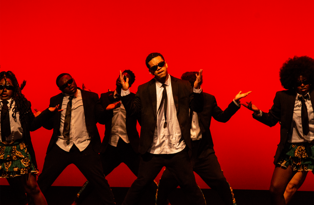 The Omo Naija x Wahala Boys perform with a bright red background with dancers wearing sunglasses and strong facial expressions. Their synced movements and coordination left the crowd in awe.