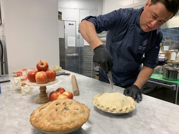 A pastry chef prepares to cut the top of a pie. The proceeds from each pie sold provided a week of hot meals for someone in need. Photo courtesy Community Servings.