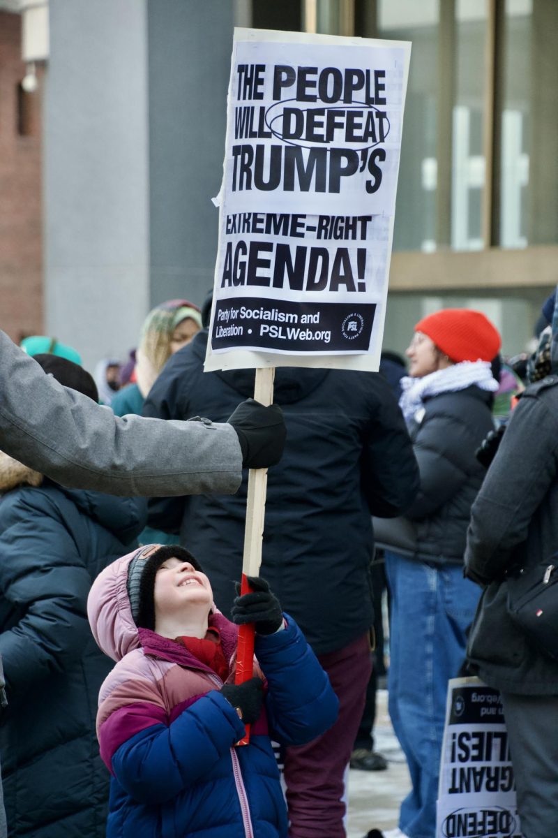 A child raises a sign that says “The People Will Defeat Trump’s Extreme-Right Agenda!” The We Fight Back organization held protests in over 70 cities across the country.