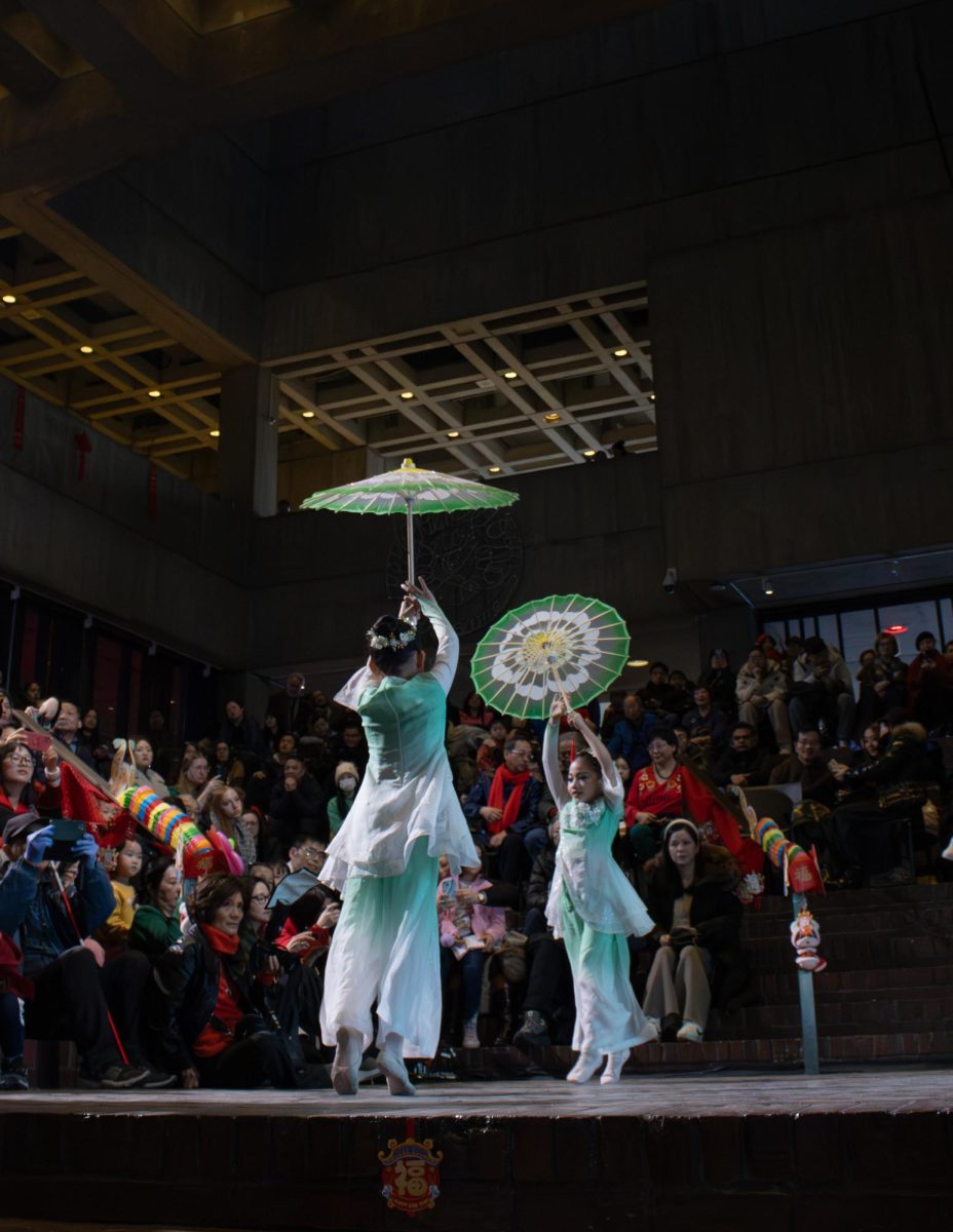 Two young girls perform a traditional Chinese umbrella dance. Their elegant performance delighted the crowd and received an outpouring of praise.