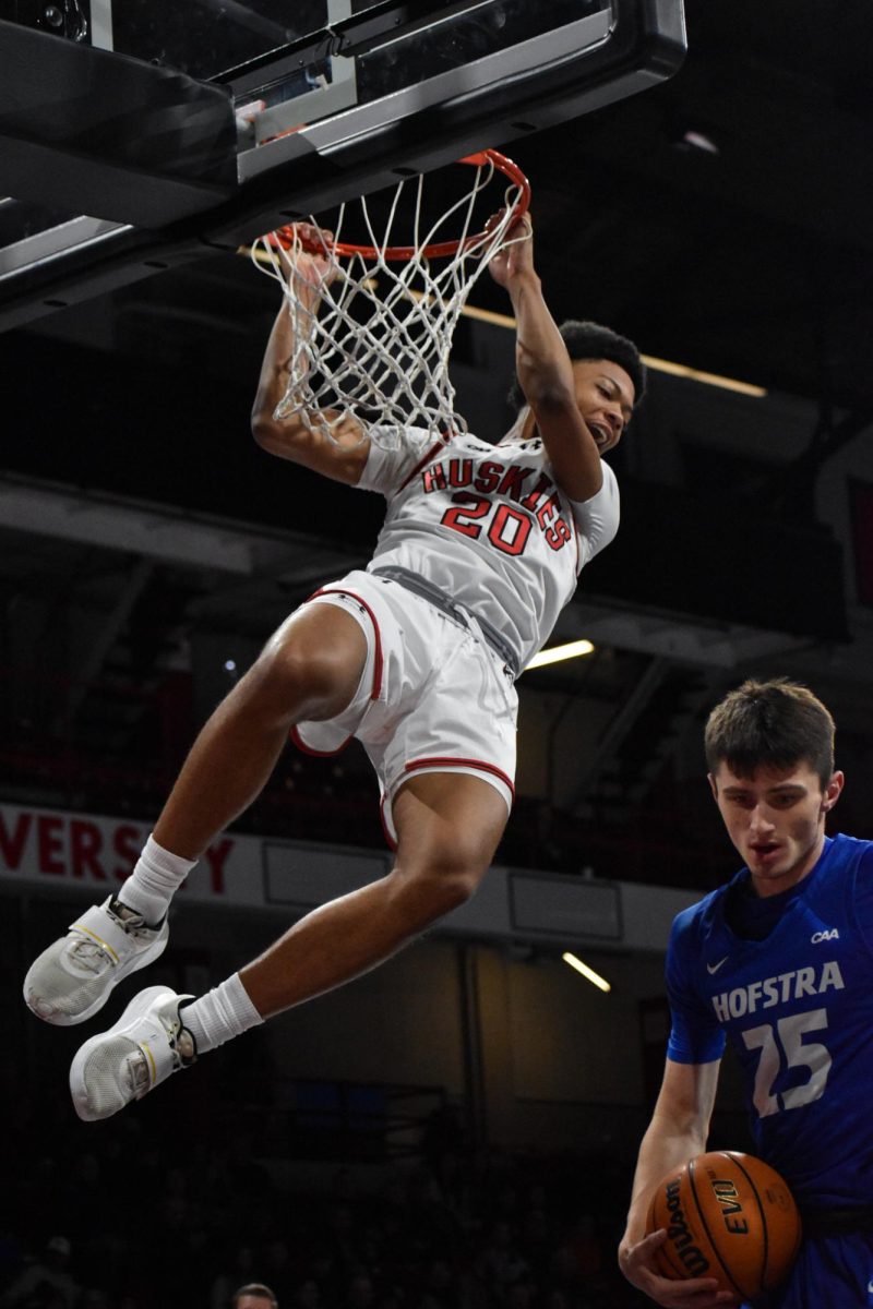 Freshman guard Ryan Williams leaps up and grabs the basketball hoop in celebration during a game against the Hofstra Pride Jan. 4. here.