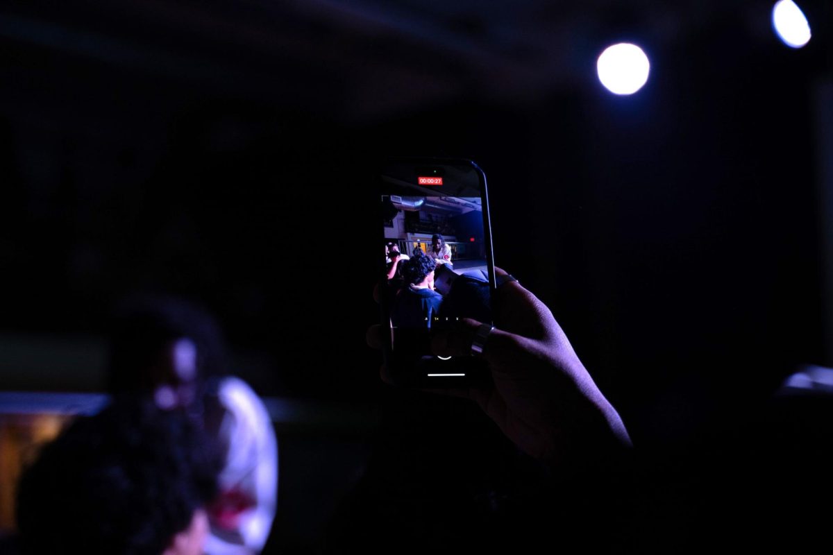 A fan films Tom as he crouches on stage. He was accompanied by a DJ for his whole set.