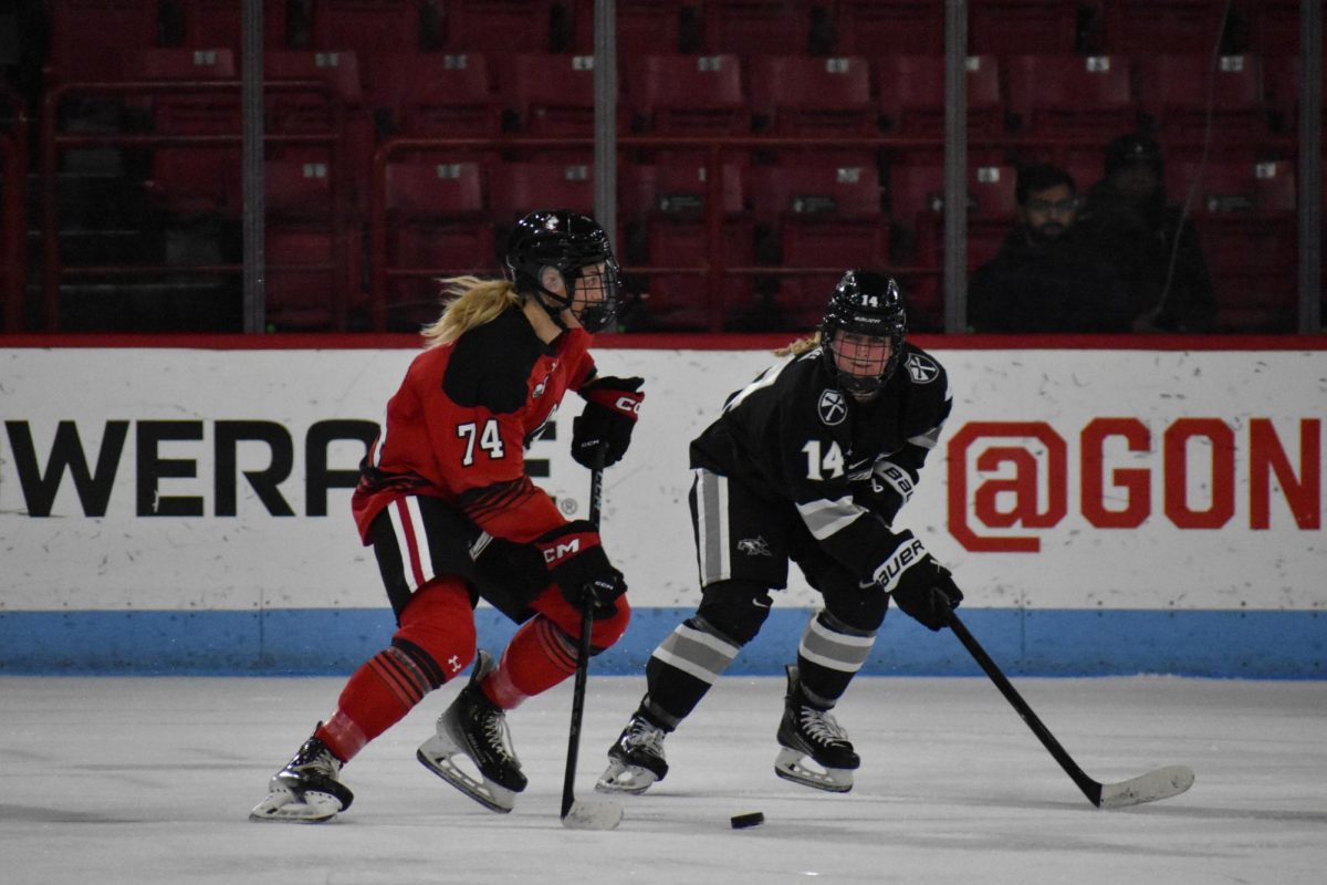 Graduate student forward Jaden Bogden skates down the ice with the puck. The Huskies were coming off a season high Jan. 18 after taking Boston College down in Matthews Arena for the Beanpot semifinals 4-2 Jan. 14.