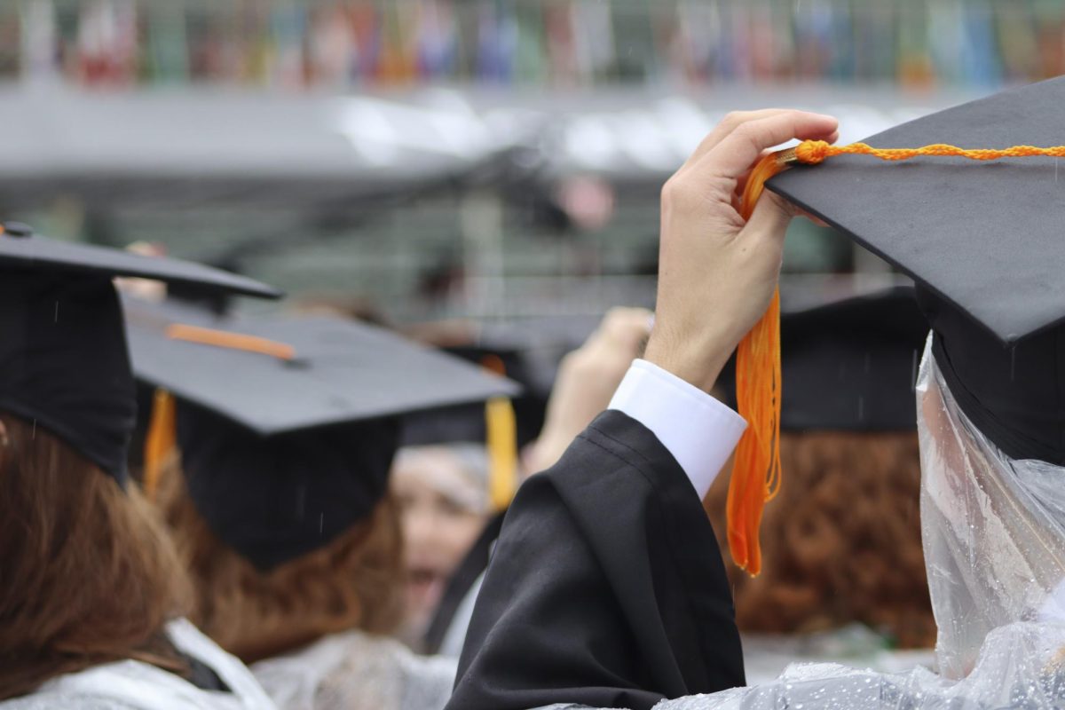 A graduate holds their cap at the 2024 undergraduate commencement ceremony in Fenway Park. Despite the rainy weather thousands of students celebrated their graduation.