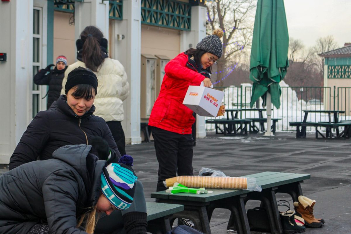 An IceFlow attendee pours a cup of hot chocolate brought by Schran. Schran said she arrived nearly an hour early to set out the hot chocolate along with extra gloves for her students, greeting each person as they arrived.