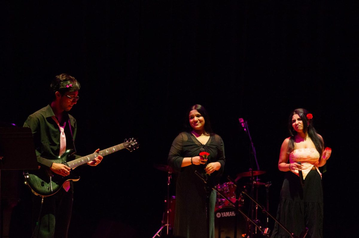 Aaroh’s guitarist plays a solo while two singers watch. The singers danced along to the tunes.