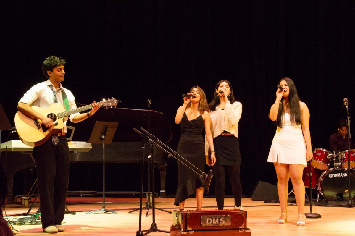 Aaroh’s guitarist strums as three members sing a Bollywood set. The performers changed their outfits from traditional to western, depending on the genre.