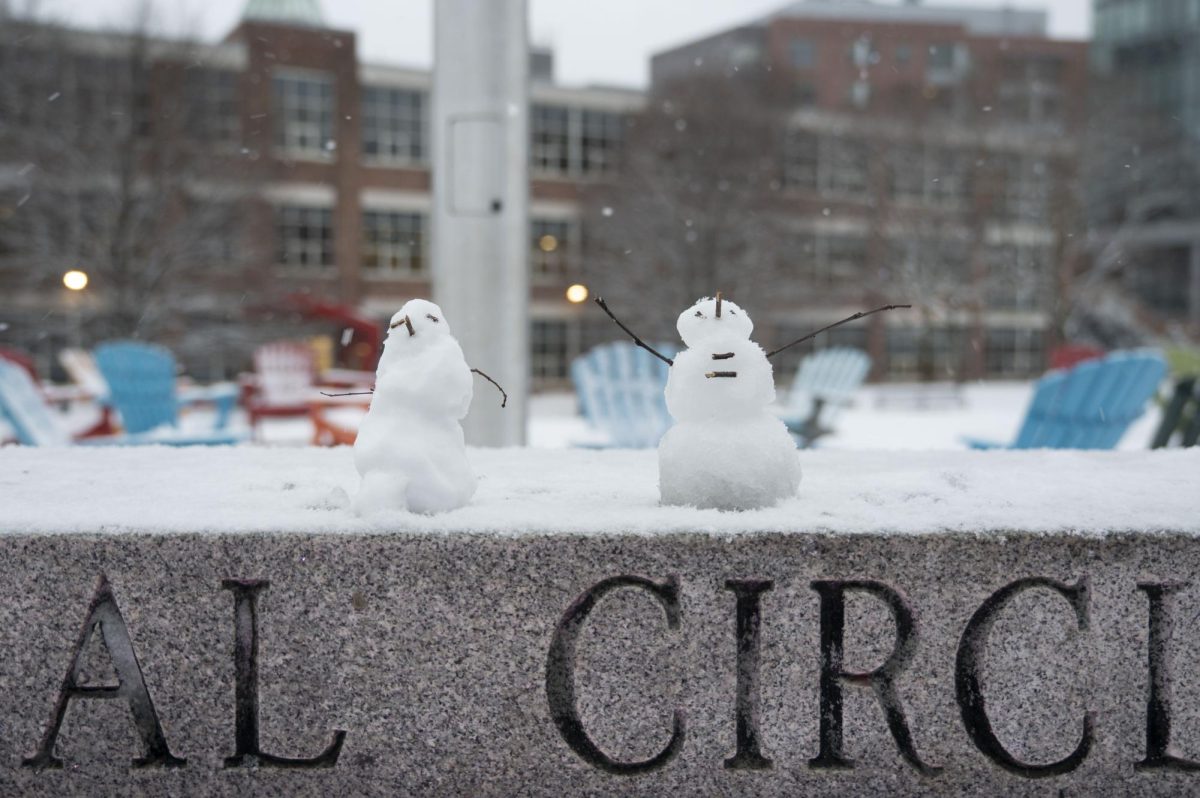 Two miniature snowmen sit on the Centennial Common ledge Jan. 11. One snowman was fashioned to have its stick-hands raised to the sky, as if it were enjoying the snow itself.