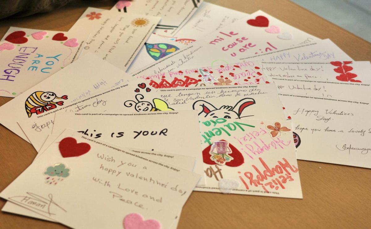 Valentine’s Day cards with bright colors and encouraging messages are spread across a table. Each reflected the personality of their creator.