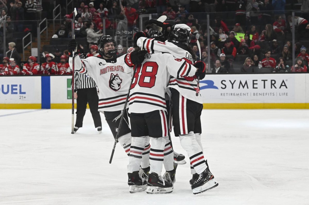 The team hugs in celebration Jan. 21. The Huskies took on the Terriers Feb. 4 for the first time since Northeastern’s victory in the Beanpot tournament.