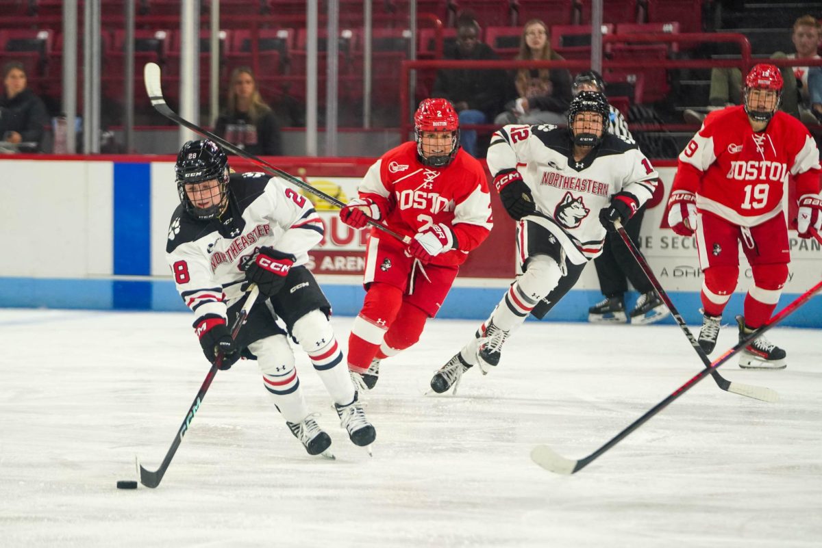 Ella Blackmore drives the puck away from her BU opponent Oct 11, 2024. Blackmore scored the first goal for the Huskies Feb. 4.