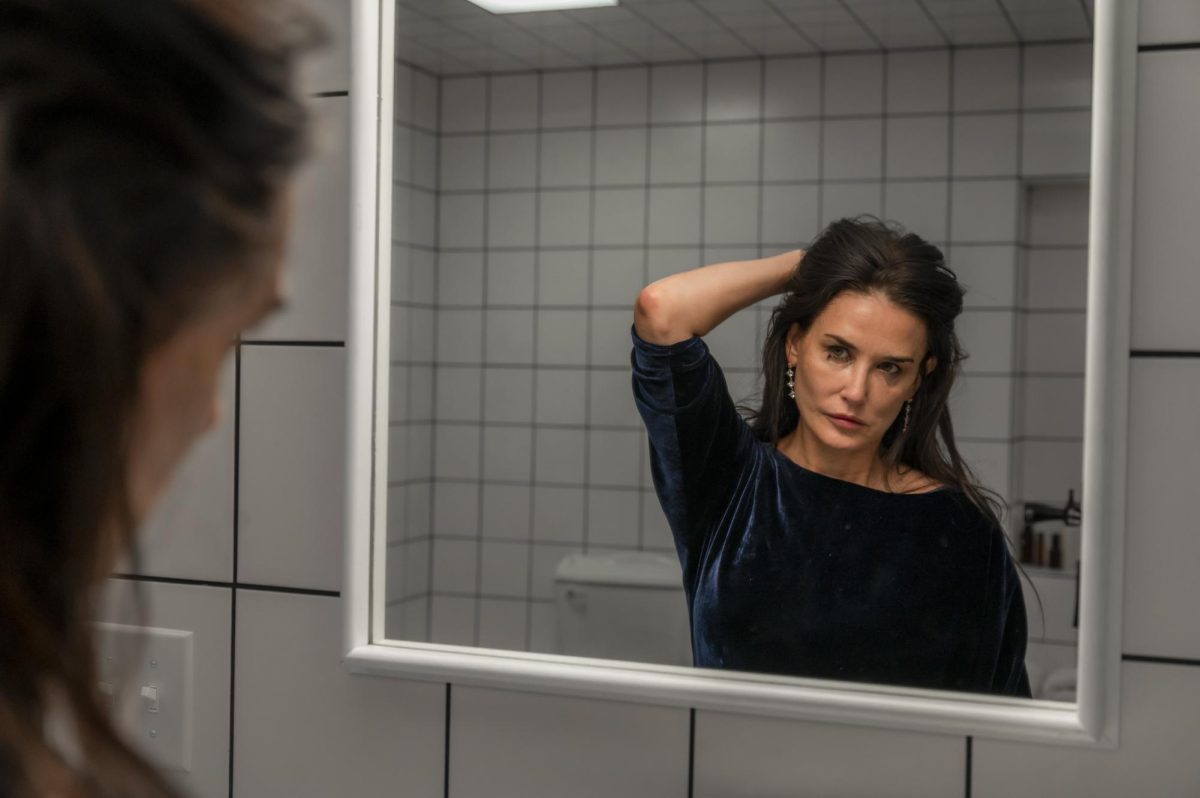 Elisabeth Sparkle (Demi Moore) gazes at herself in the mirror in "The Substance." Throughout the film, Elisabeth struggled with self-confidence and body image before succumbing to a mutated fate. Photo courtesy Mubi, Metropolitan Filmexport.