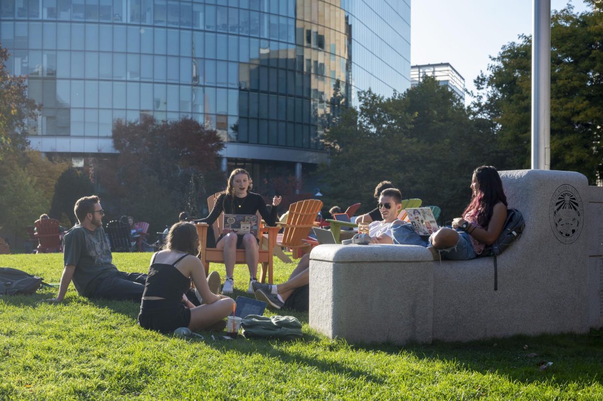 Students animatedly chat with each other on a sunny afternoon on Centennial Common Oct. 22, 2024. Many students applied to Northeastern for its academics, but also for its array of clubs and atmosphere.