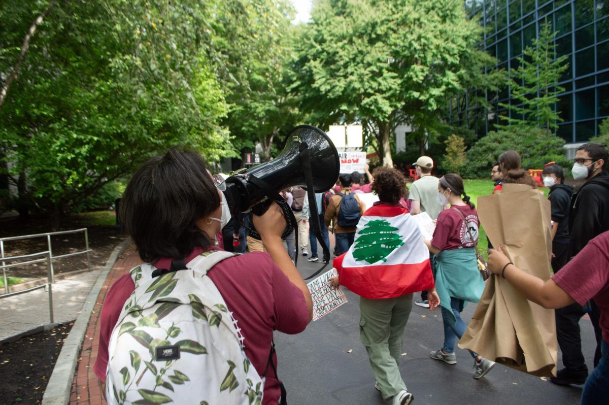 A protester at a GENU-UAW rally uses a megaphone to amplify their message to passersby Oct. 2, 2024. The Trump administration changes in national policy affected international students, members of the LGBTQ+ community and more.