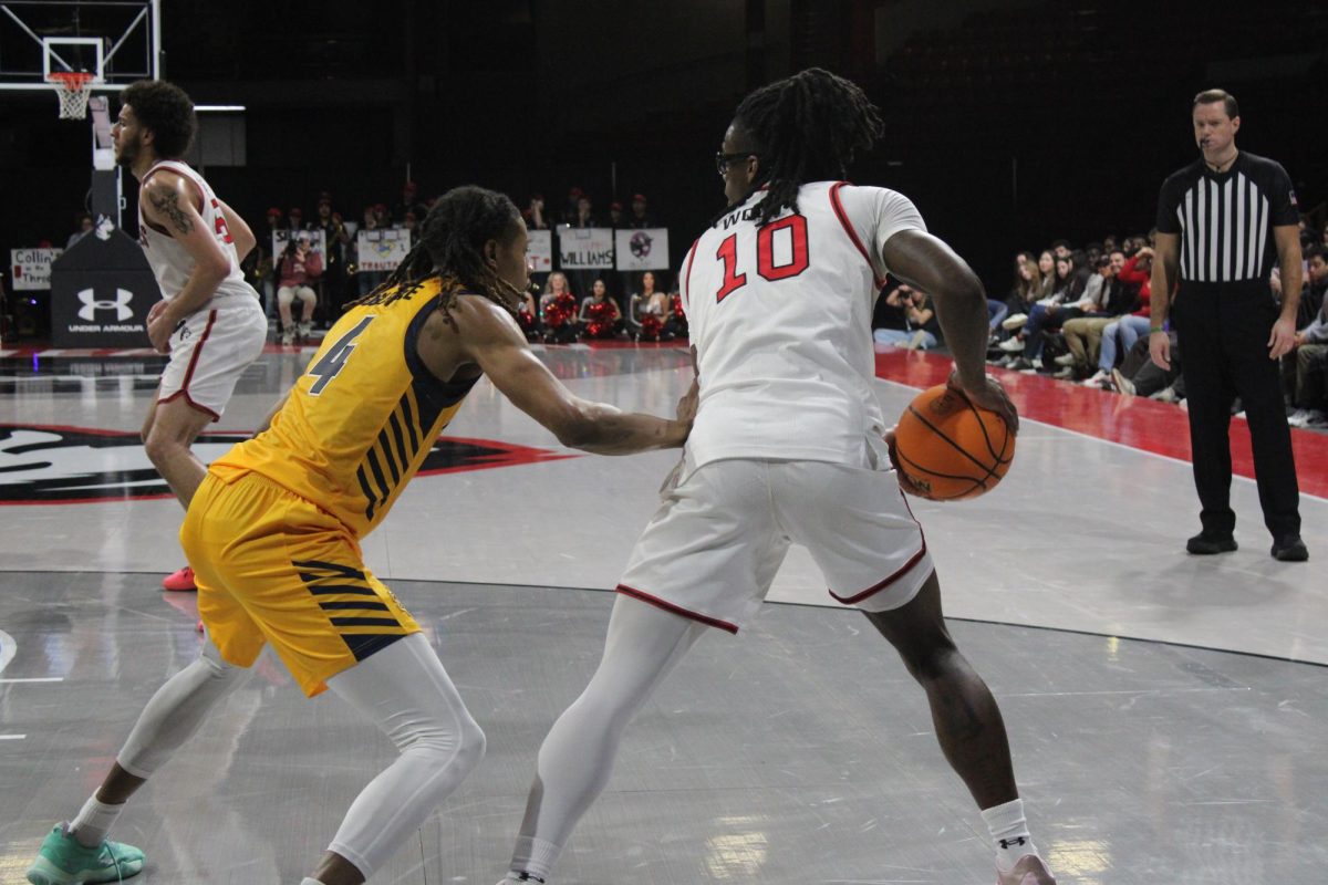 Harold Woods holds the ball away from his opponent Feb. 27. Woods entered the transfer portal March 24.