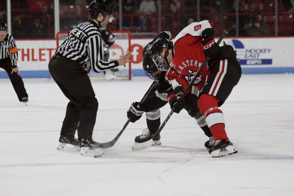 Senior forward Ryan McGuire fights for the puck against his opponent March 8. The Huskies beat Merrimack College 3-2 in double overtime in the opening round of the Hockey East playoffs March 12. 