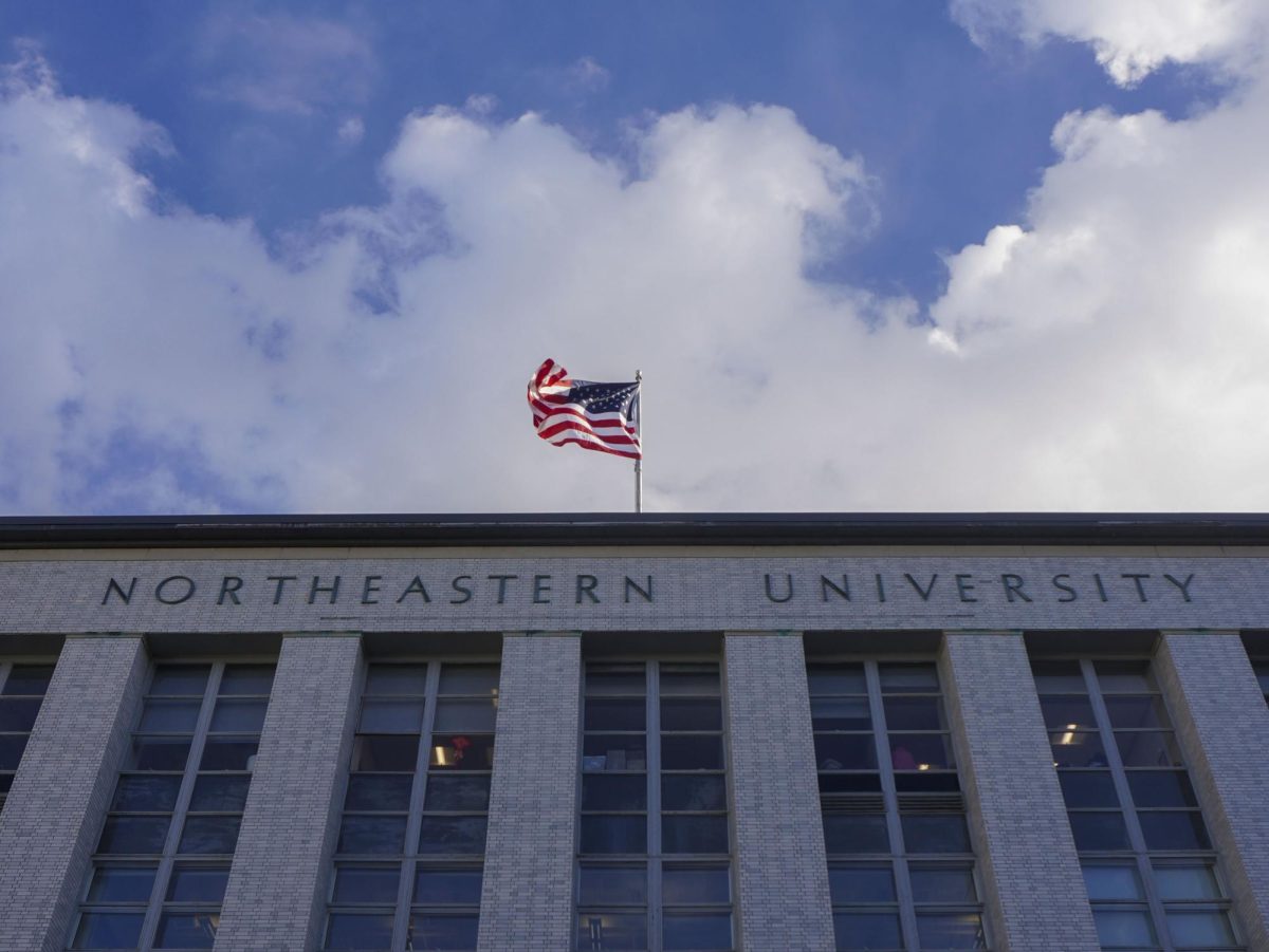 An American flag flows in the Boston wind on top of Northeastern University's Ell Hall. Many students expressed concern about co-op positions being threatened after the Trump administration rescinded grants and funding.