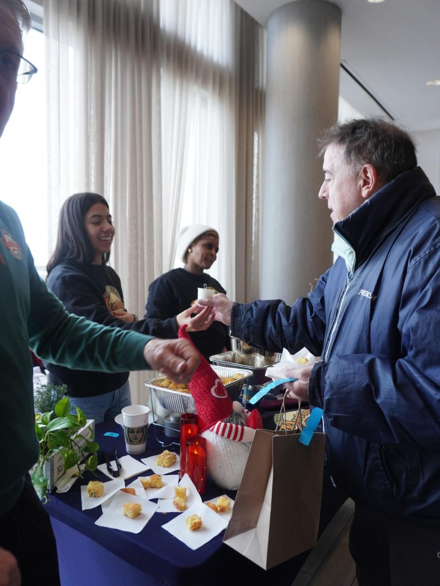 A man receives a cup of chili from a vendor. Additional foods such as cornbread and chips were also available at each chili station.